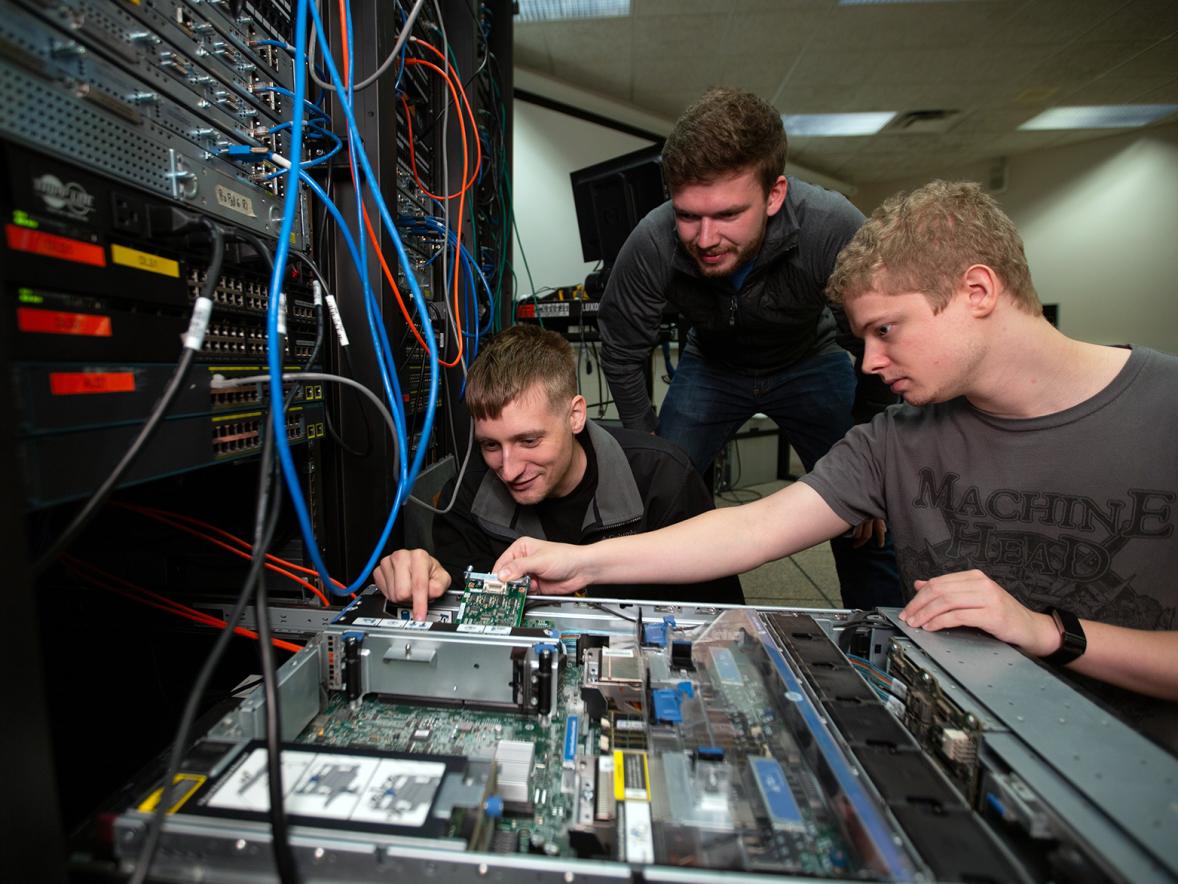 UW-Stout students work on a computer server in a lab.