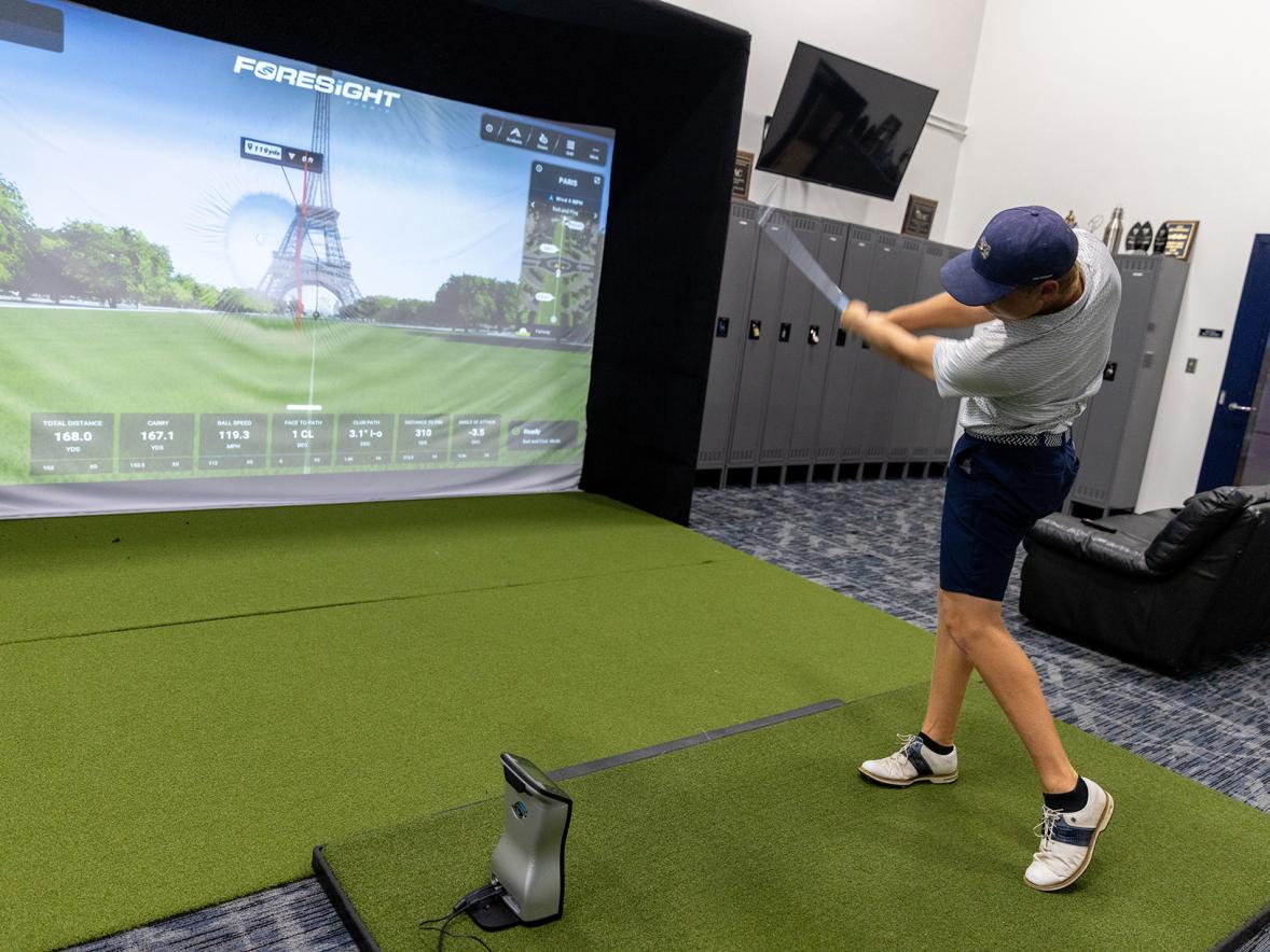 A member of the UW-Stout men’s golf team uses one of the two golf simulators at the center.