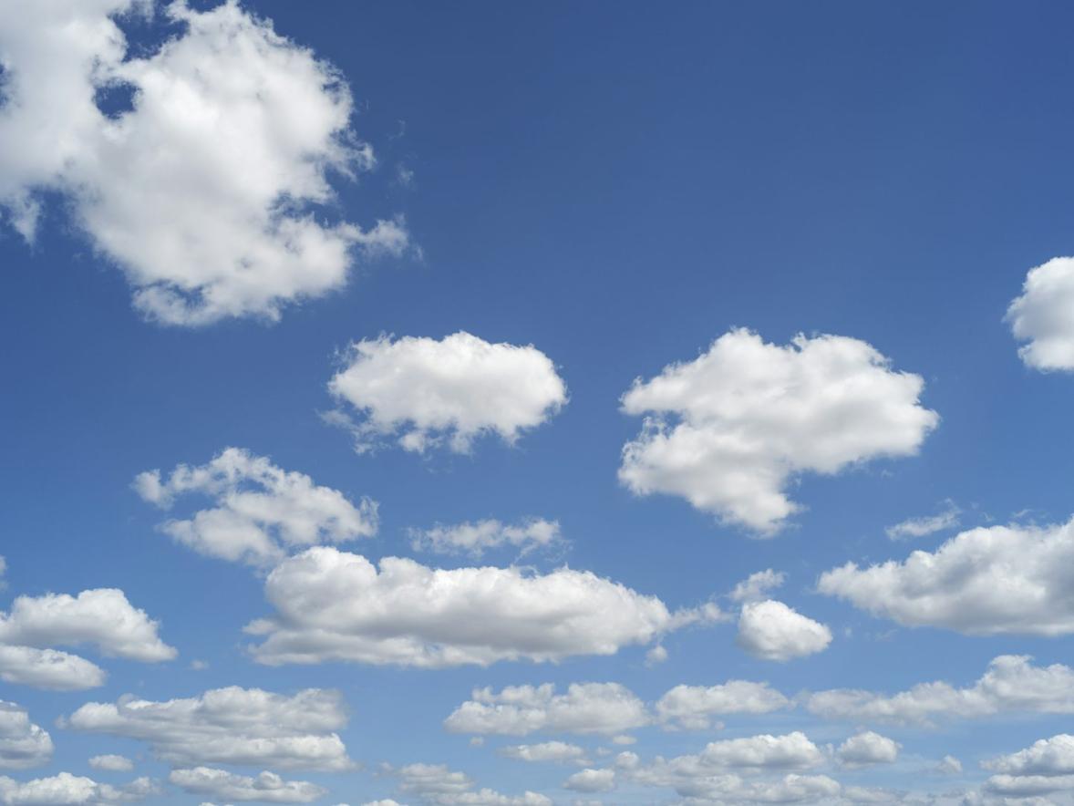 Blue sky with puffy clouds on a sunny day.