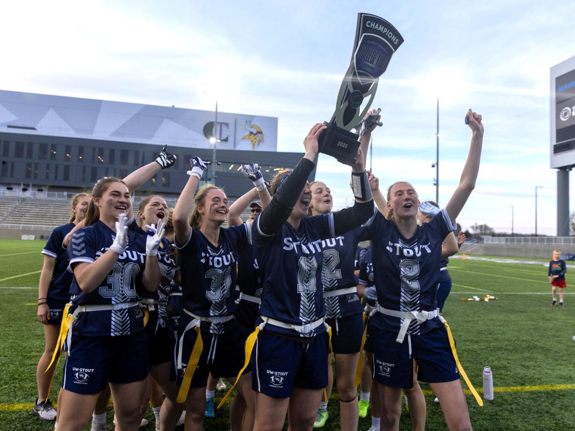 Quarterback Allison Letcher hoists the trophy after the Blue Devils won the inaugural Midwest College Women’s Flag Football League Championship.