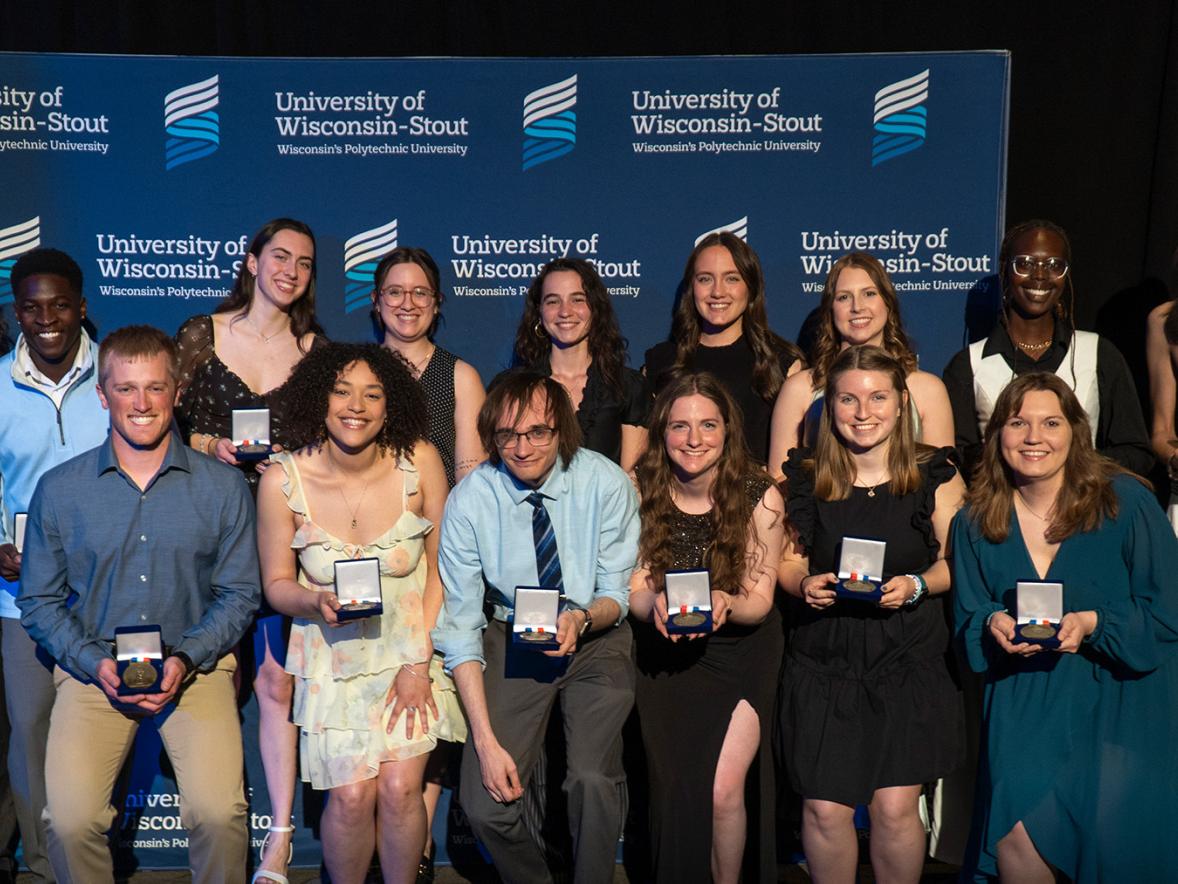 A group of students holding award plaques