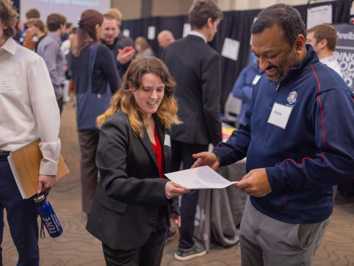 Two people talk at a career fair