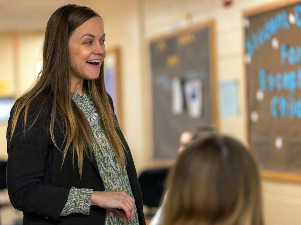 A woman speaks to students