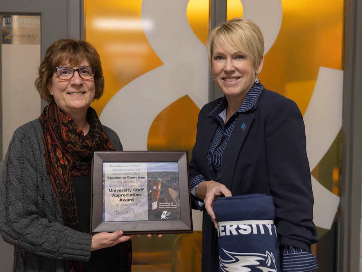 Two women pose with award