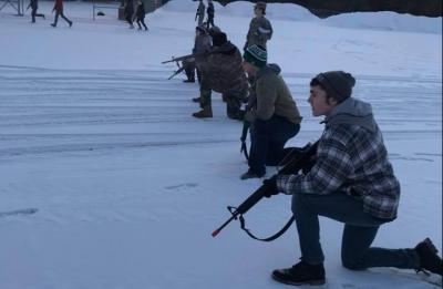 ROTC studens bounding in snowy parking lot.