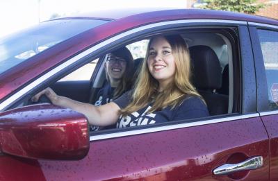 Two Stout students in a red car.