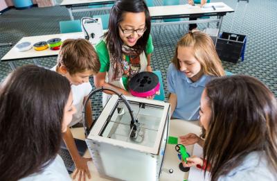 Students and teacher at a 3D printer in a Fab Lab.