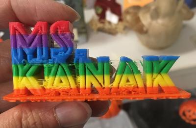 3D printed name: Ms. Kanak, in rainbow letters.