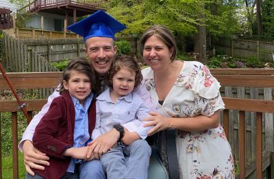 Josh Hellenbrand, management graduate, with his family at their home in Baltimore.