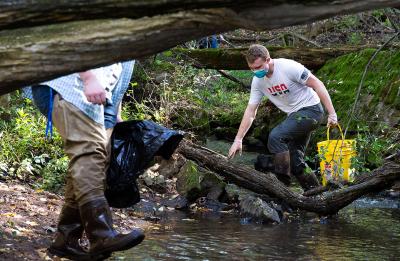Chris Jones, right, president of the Natural Areas Club, pulls items from the creek.