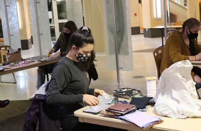 UW-Stout student Megan Otte pins together fabric for face masks. Student volunteers are making the face masks for the community.