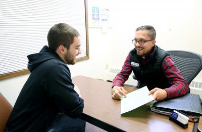 Advisor Darren Ward meets with a student. Photo taken pre-COVID.