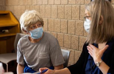 Custodian DiAnn Rudiger speaks with a vaccinator before receiving her inoculation.