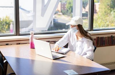 A student studying on the 4th floor of the University Library.