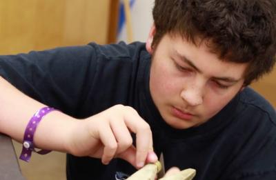 A student filing a ring made in the jewelry track.