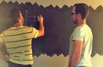 Lance, at left, and Vincent Wheeler working on a makeshift chalkboard they used to create the math and science to look into the future of PV windows.
