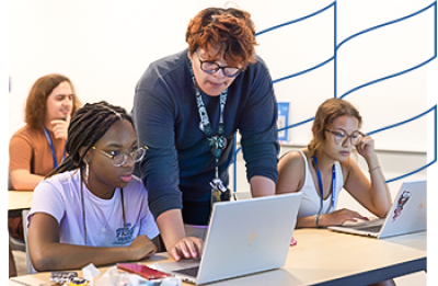 Student teacher aids student in classroom setting.