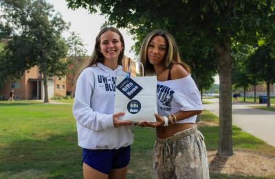 Students holding a gift from home bag