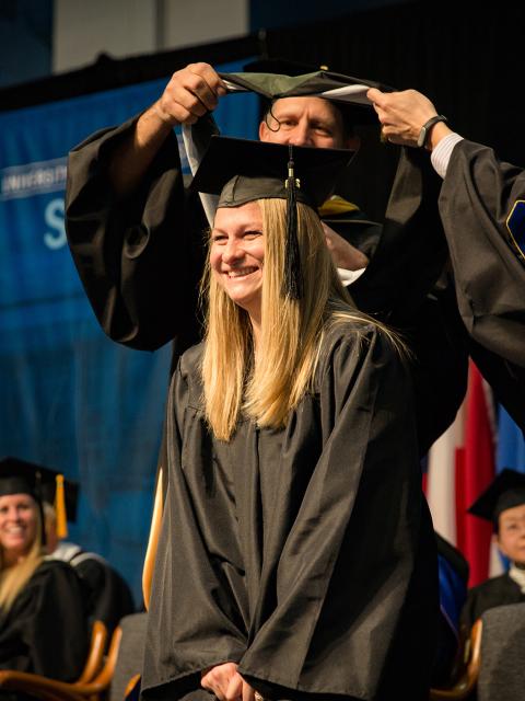 Britta Miller Faculty members give Britta Miller her hood as part of receiving her Master of Science degree.