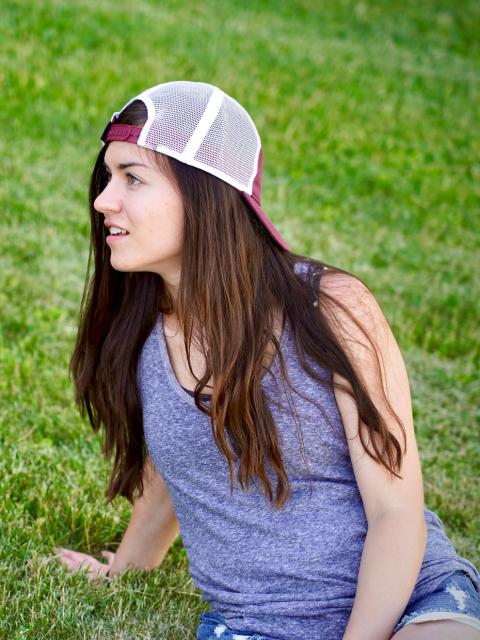 Ivy Huwald sitting in grass at a farm