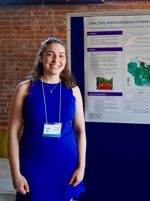 Elizabeth Saunders posing with her research poster
