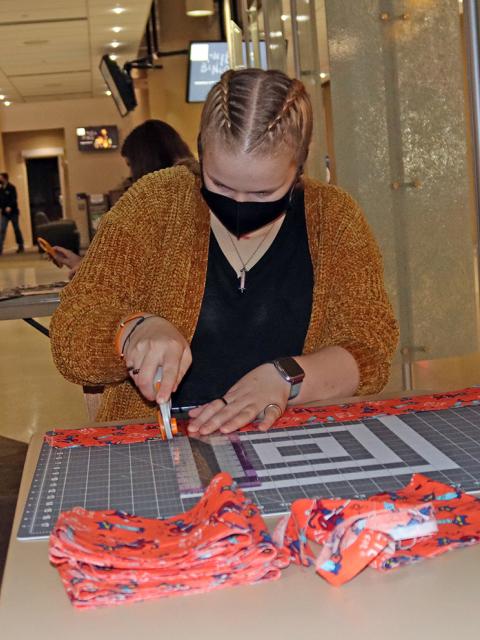 Photo of Maggie Brehmer cutting fabric.