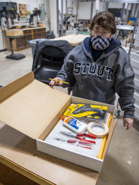 Weissman checks one of the kits, which contain tools and materials to help online students create 3D projects this semester.