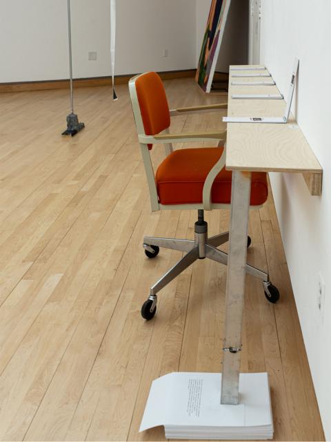 A vintage chair and thin table, displaying collections of Beck Slack's photography and AI interpreted poetry.