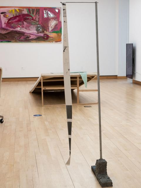 A metal and concrete stand displaying Beck Slack's photography and AI interpreted poetry.