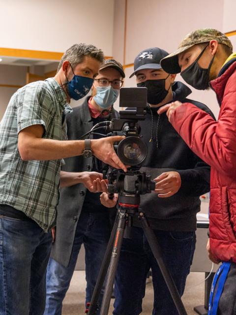 Assistant Professor Keif Oss, left, talks with students during the workshop about using Canon camera.