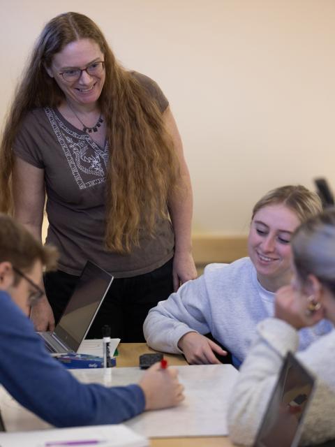 Laura McCullough works with students in a physics class.