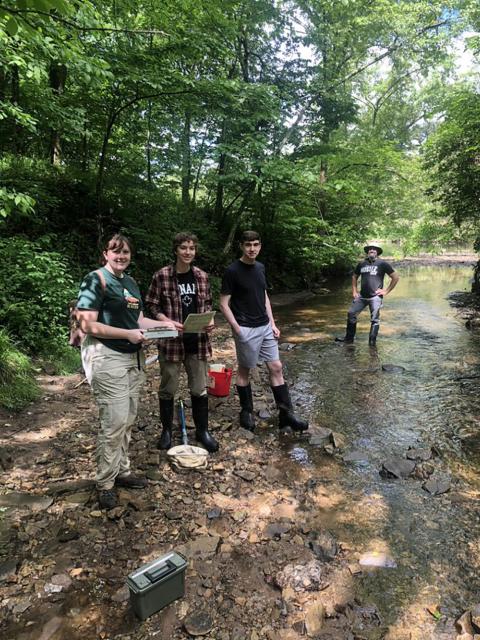 From left, UW-Stout students Britney Serafina, Kal Breeden and Dylan Kostuch and Associate Professor Keith Gilland conduct research in a stream this summer as part of the Red Cedar Basin Monitoring Program.