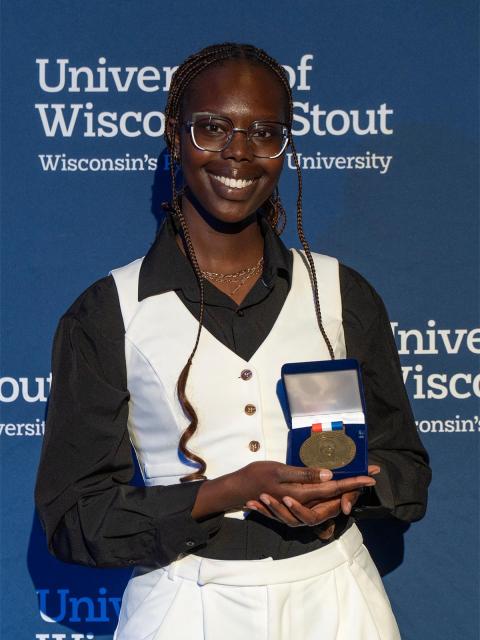 A student poses with their awarded medallion.